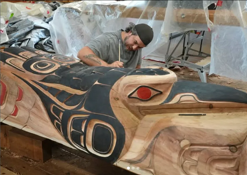 Master Carver Billy Yovanovich (Kuuhlaanuu) puts finishing touches on one of the new poles for Skidegate Days.